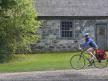 Cycliste devant une maison de campagne